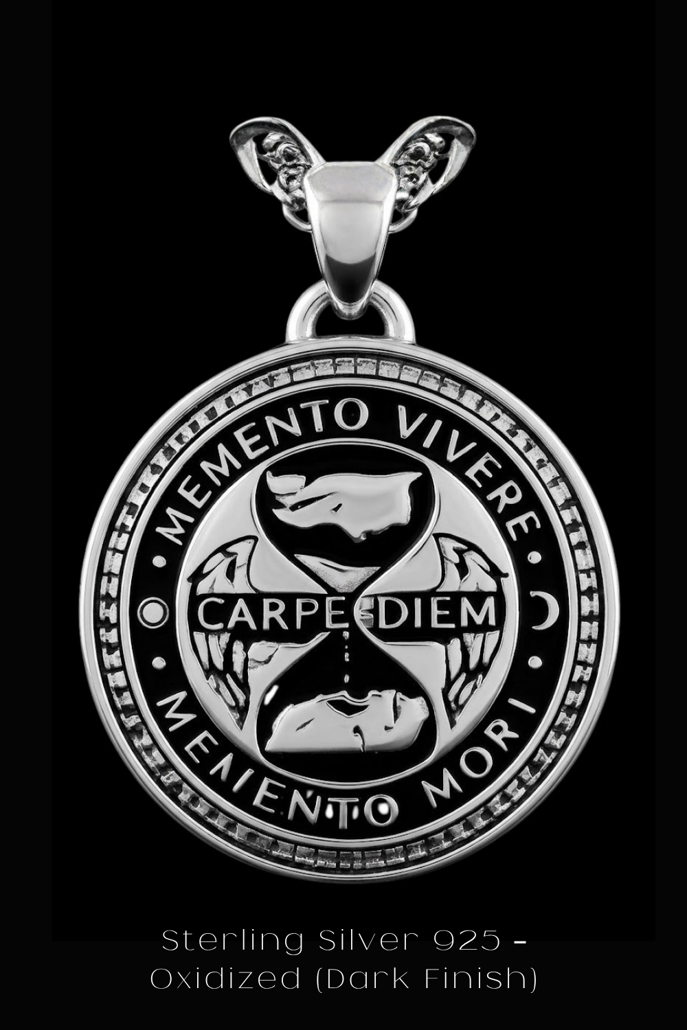 A silver pendant with a circular design featuring the Latin motto "Memento Vivere" and the words "Carpe Diem" and "Memento Mori". The pendant is set against a black background, and the image contains no text.