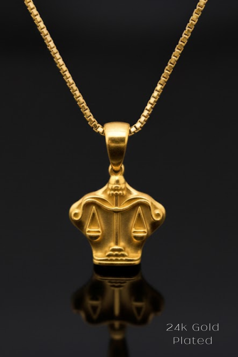 A gold-colored pendant necklace with a pendant in the shape of scales of justice, symbolizing justice and fairness.
