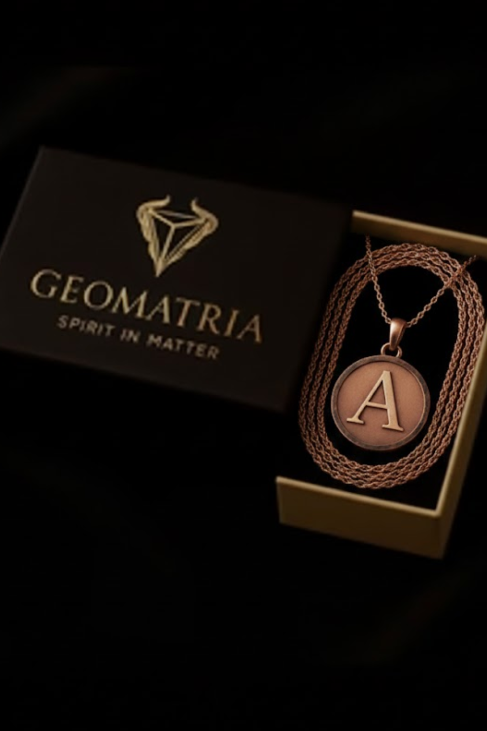 a necklace with a large letter "A" pendant, displayed in a box with the brand name "Geomatria" written on it.