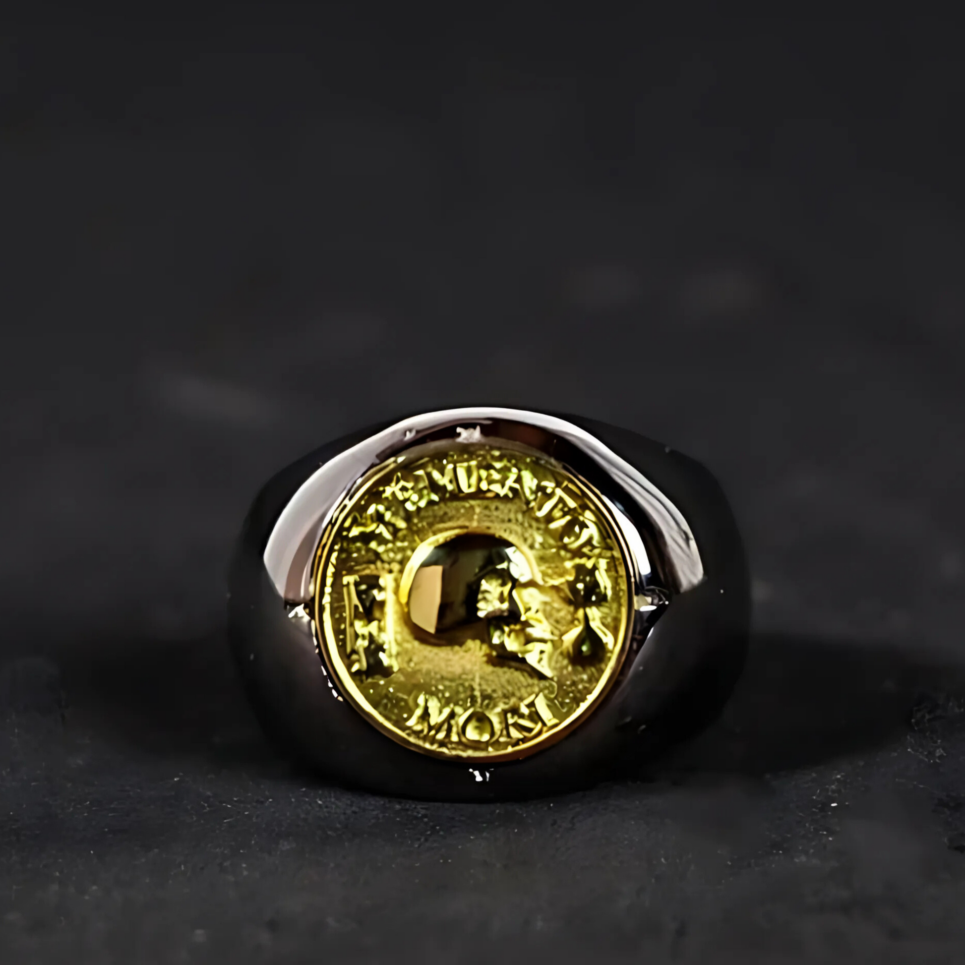 A ring with a gold-colored emblem on it, placed on a dark surface.