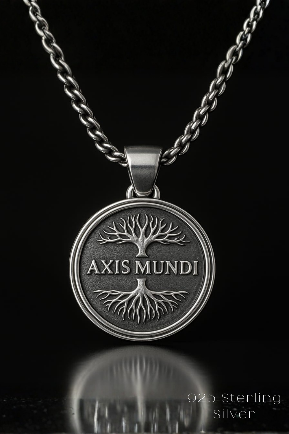 A silver-toned pendant necklace with a circular medallion featuring the text "AXIS MUNDI" and a tree-like design.