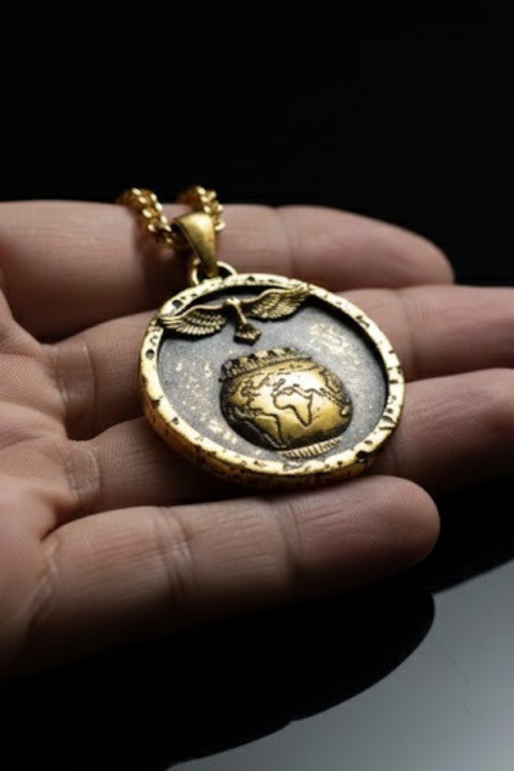 A gold-colored pendant necklace with a circular design featuring a globe and wings.