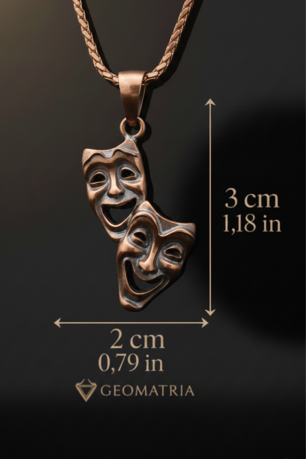a pendant necklace with two bronze-colored theatrical masks hanging from a chain. The necklace is described as having a length of 3 cm and a width of 0.79 in.