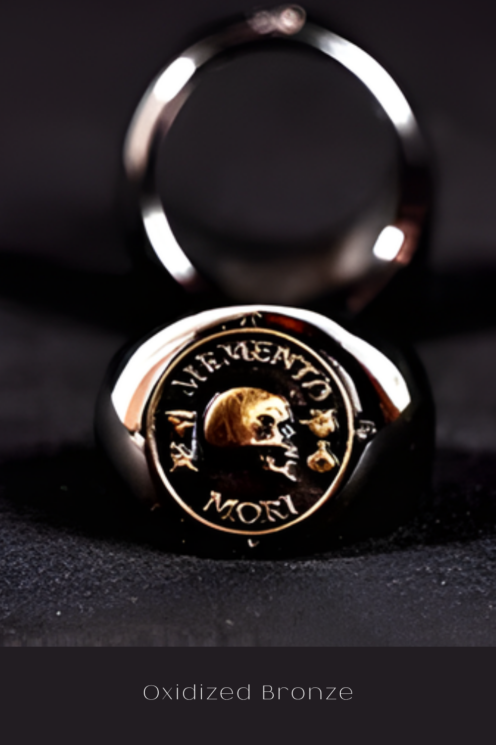 An Oxidized Bronze ring with a skull design on it, placed on a dark surface.