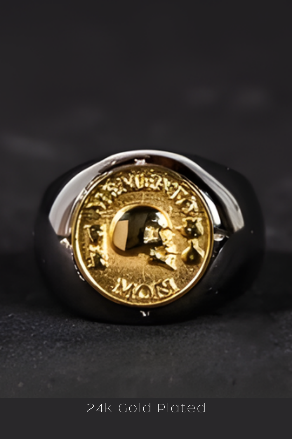 A 24k gold plated ring with a skull design on a black background.