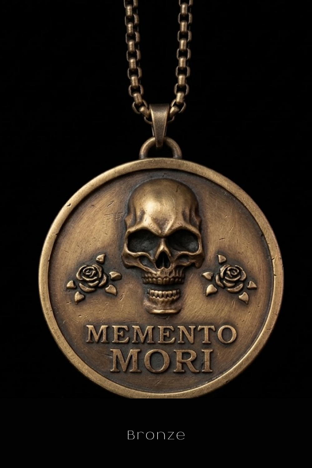 A bronze pendant necklace with a skull design and the text "MEMENTO MORI" on it.