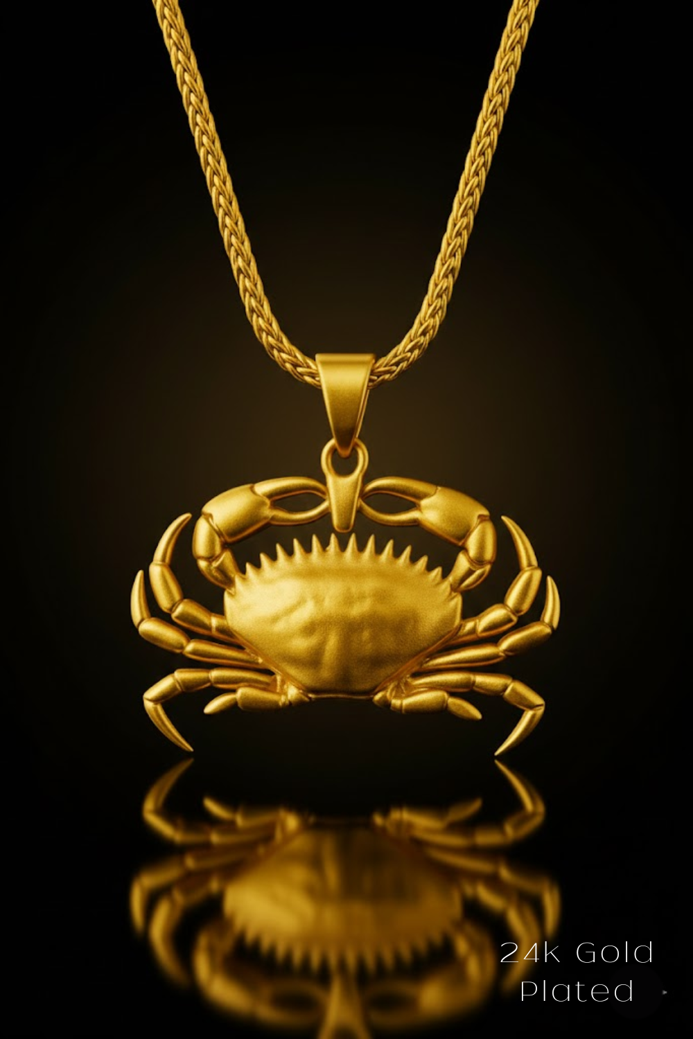 A 24K gold-plated pendant featuring a detailed crab design is displayed against a black background.